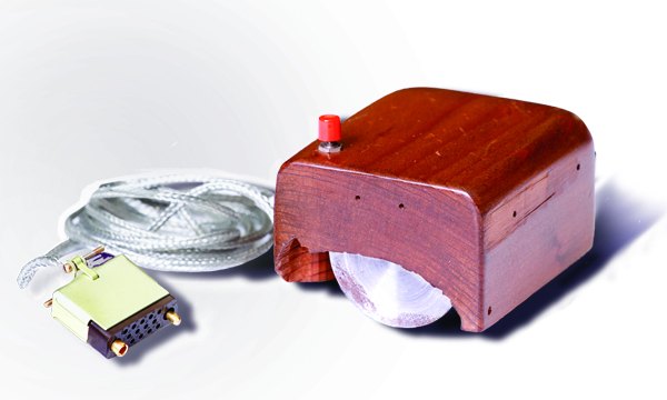 The first computer mouse: a hand-carved wooden shell over two metal wheels, with a single red button and a cord