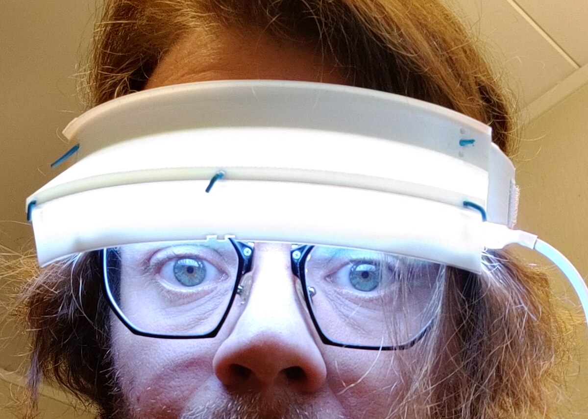 Circadius light visor worn on the forehead, glowing